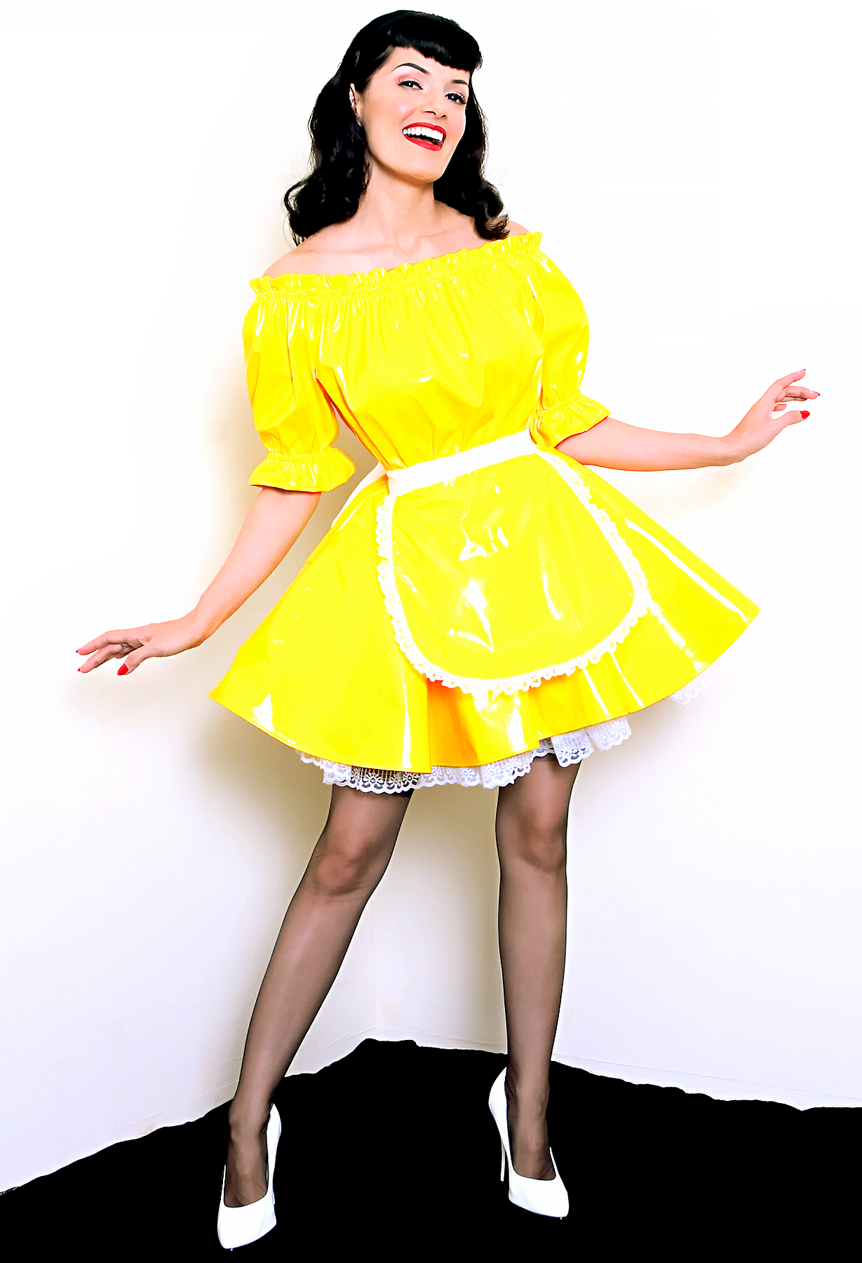 Bernie Dexter in original Versatile Fashions Elastic Maid Dress in yellow PVC w/ white lace trim apron